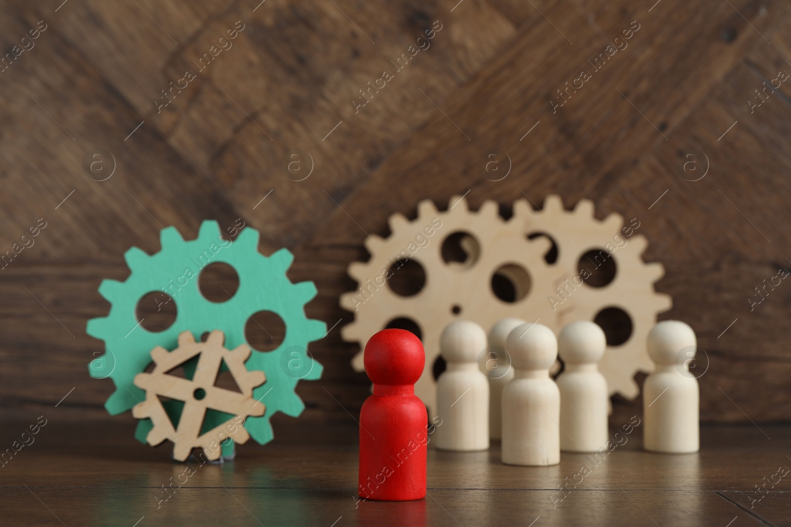 Photo of Red piece among wooden ones and gear set on table