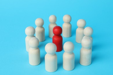 Photo of Red piece among wooden ones on light blue background, closeup