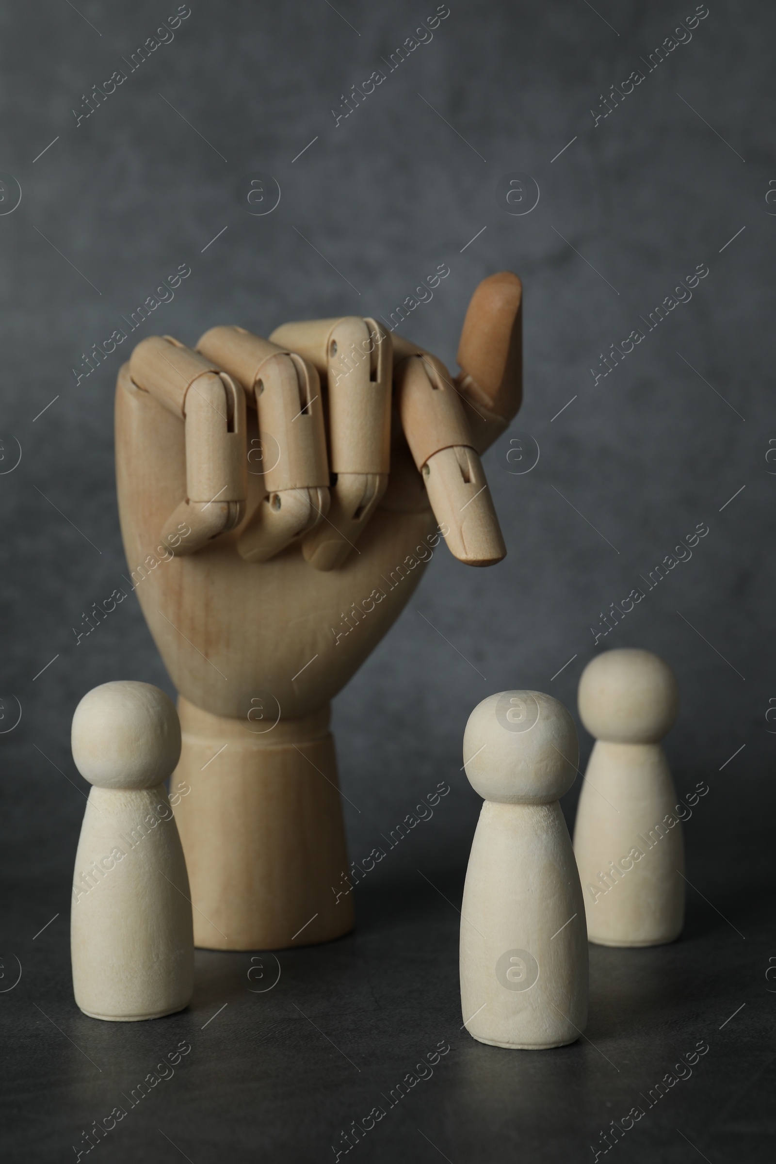 Photo of Wooden pieces and hand figure on grey table