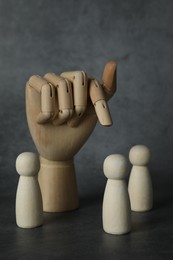 Photo of Wooden pieces and hand figure on grey table