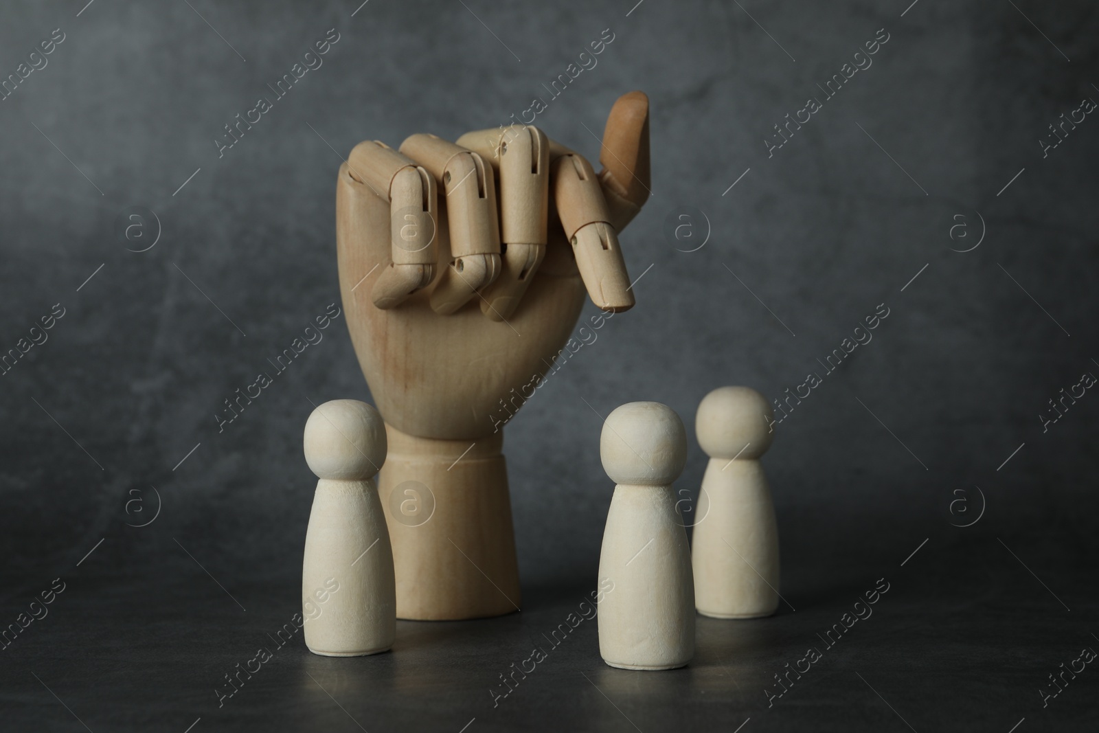 Photo of Wooden pieces and hand figure on grey table