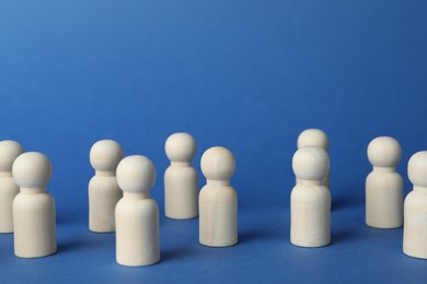 Photo of Many wooden human figures on blue background