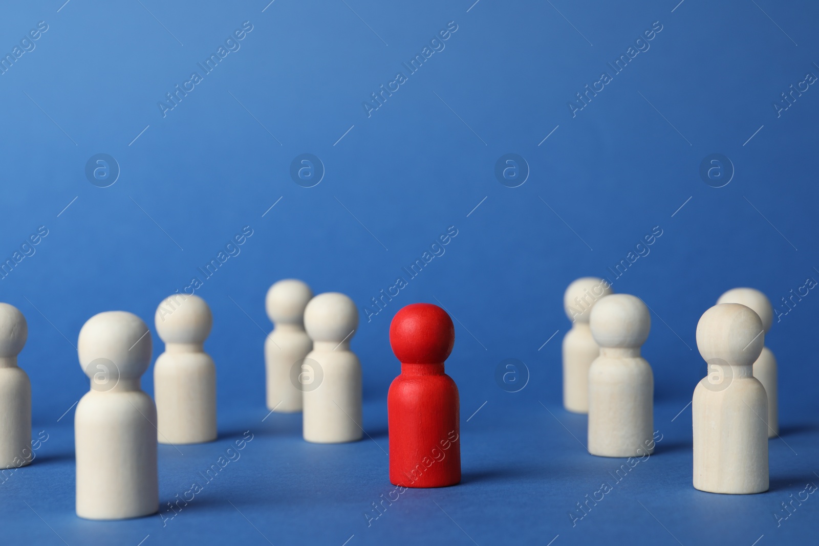 Photo of Red piece among wooden ones on blue background