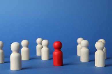 Photo of Red piece among wooden ones on blue background