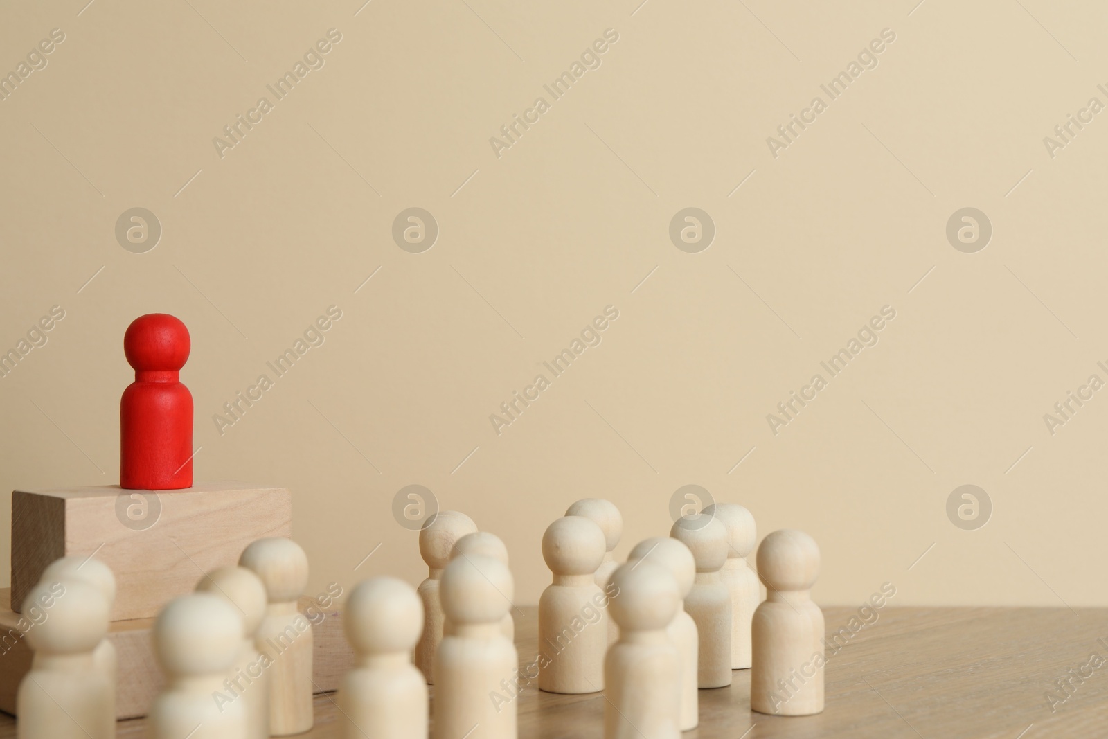 Photo of Red piece among wooden ones on table. Space for text