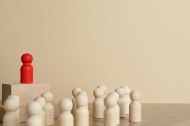 Red piece among wooden ones on table. Space for text