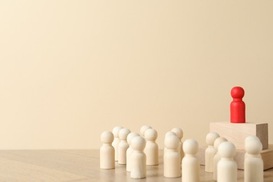 Photo of Red piece among wooden ones on table. Space for text