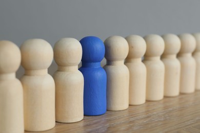 Photo of Blue piece among wooden ones on table, closeup