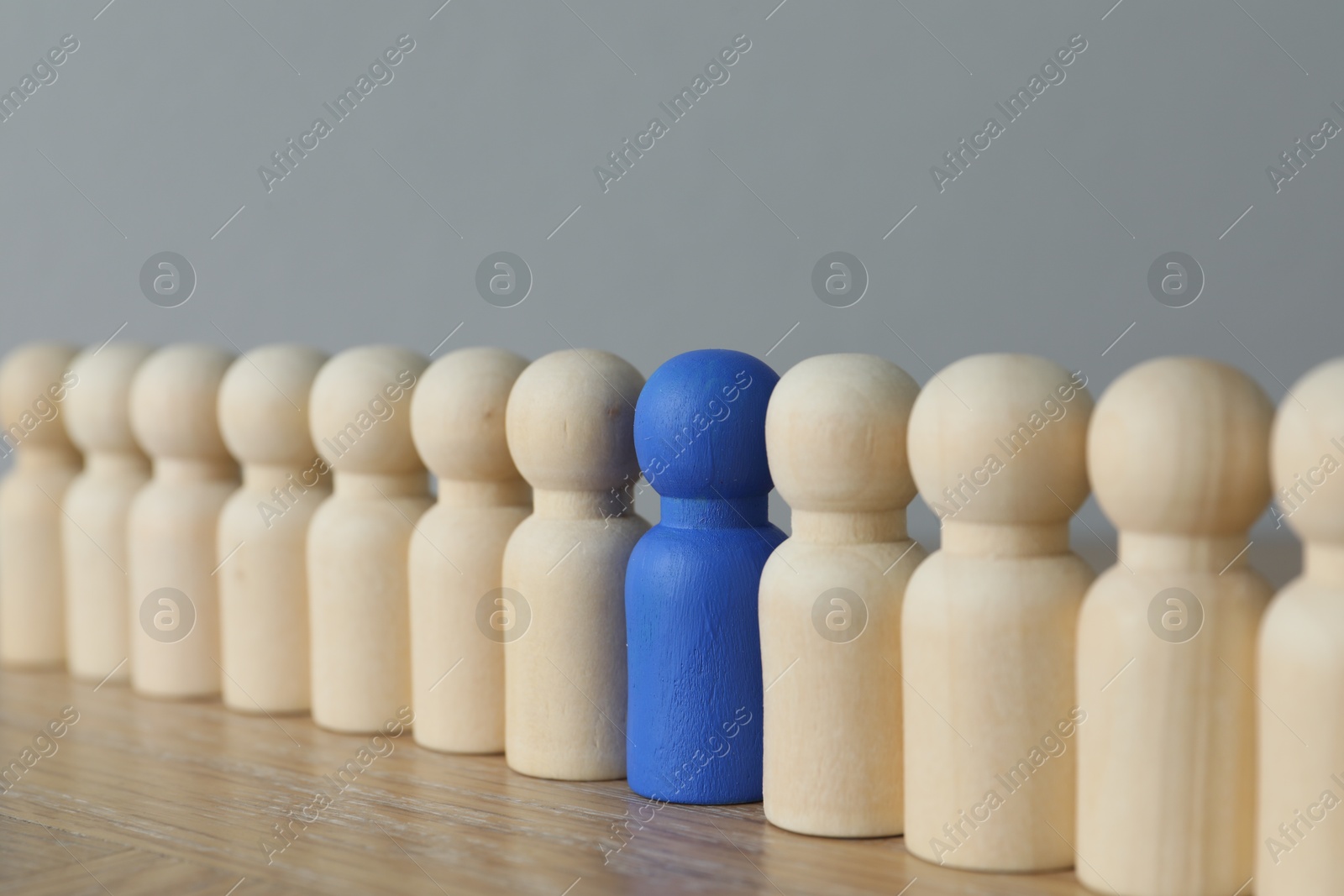 Photo of Blue piece among wooden ones on table, closeup