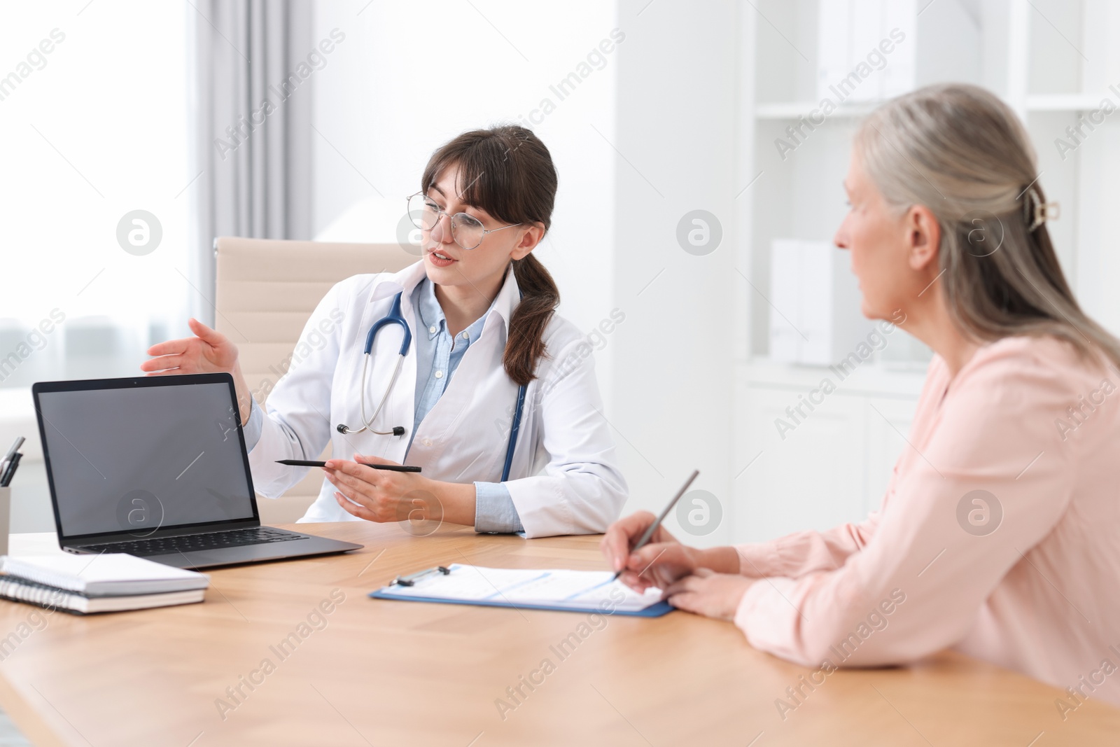 Photo of Lung disease. Doctor showing something on laptop to her patient in clinic