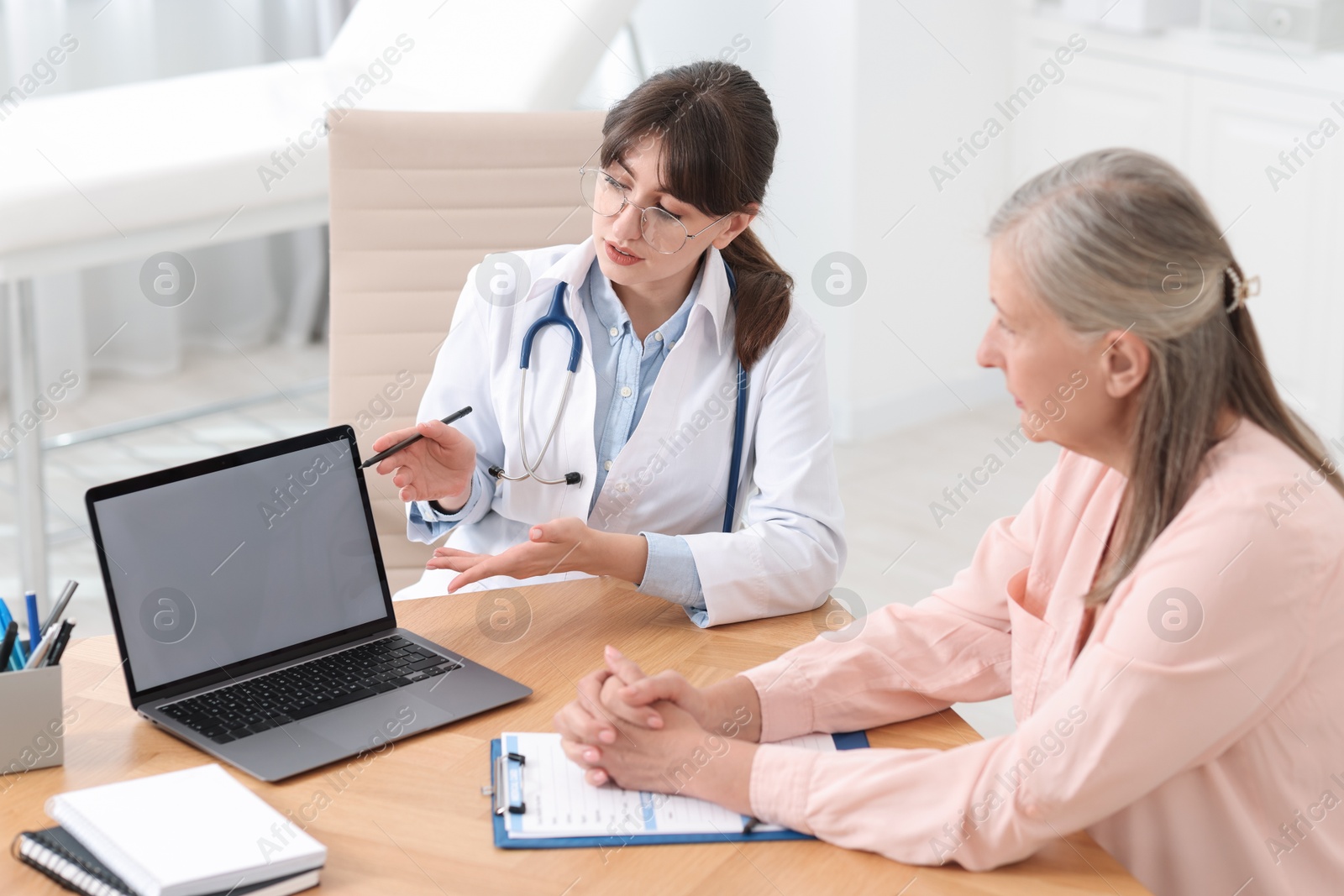 Photo of Lung disease. Doctor showing something on laptop to her patient in clinic