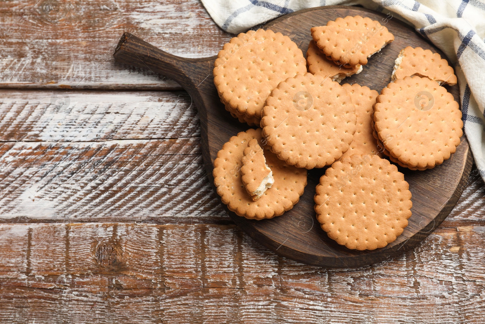 Photo of Tasty sandwich cookies on wooden table, top view. Space for text