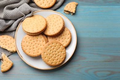 Tasty sandwich cookies on light blue wooden table, top view. Space for text