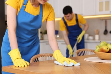 Photo of Professional janitors working in kitchen, closeup. Cleaning service