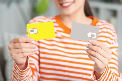Photo of Woman holding SIM cards at home, closeup