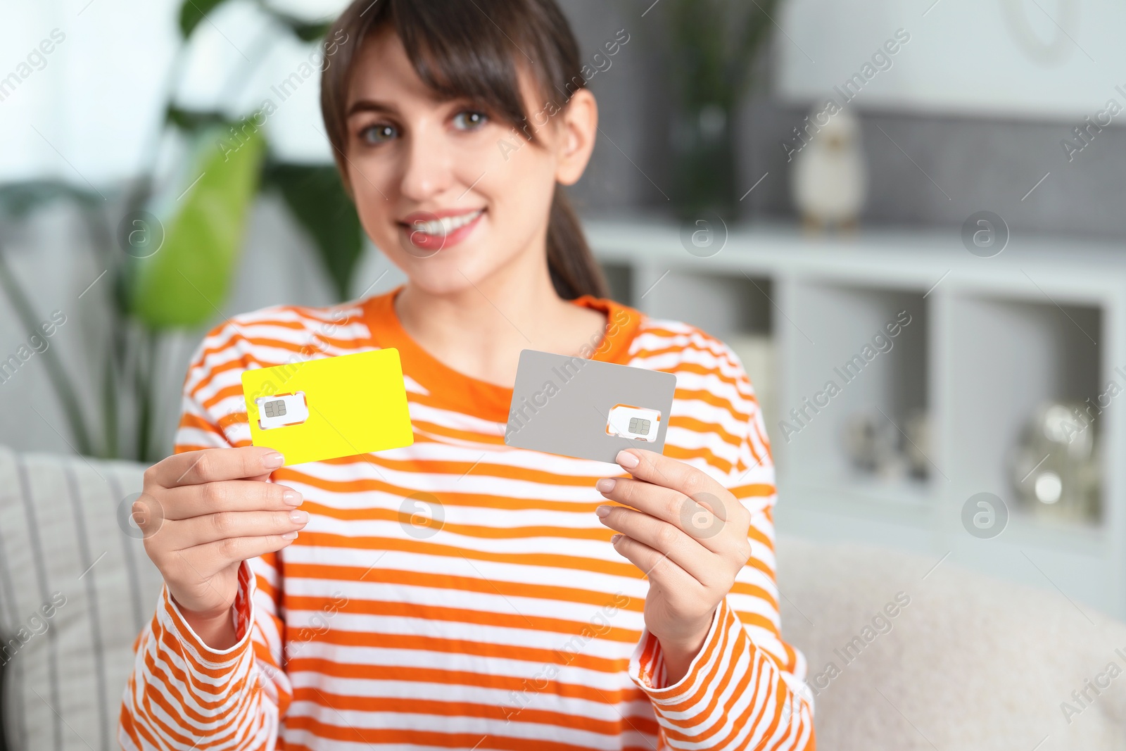 Photo of Woman with SIM cards on sofa at home, space for text