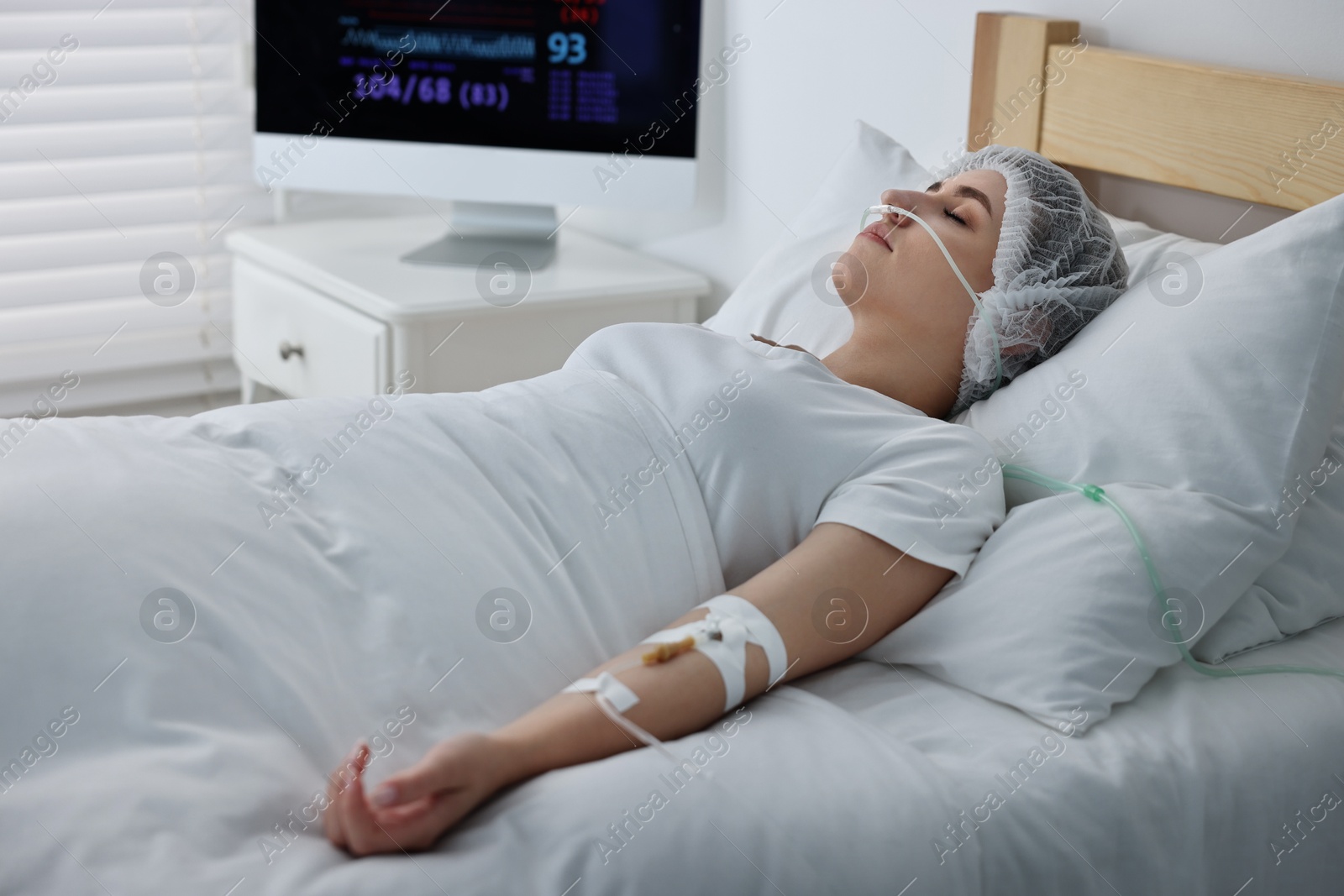 Photo of Coma patient. Young woman with intravenous drip in hospital bed