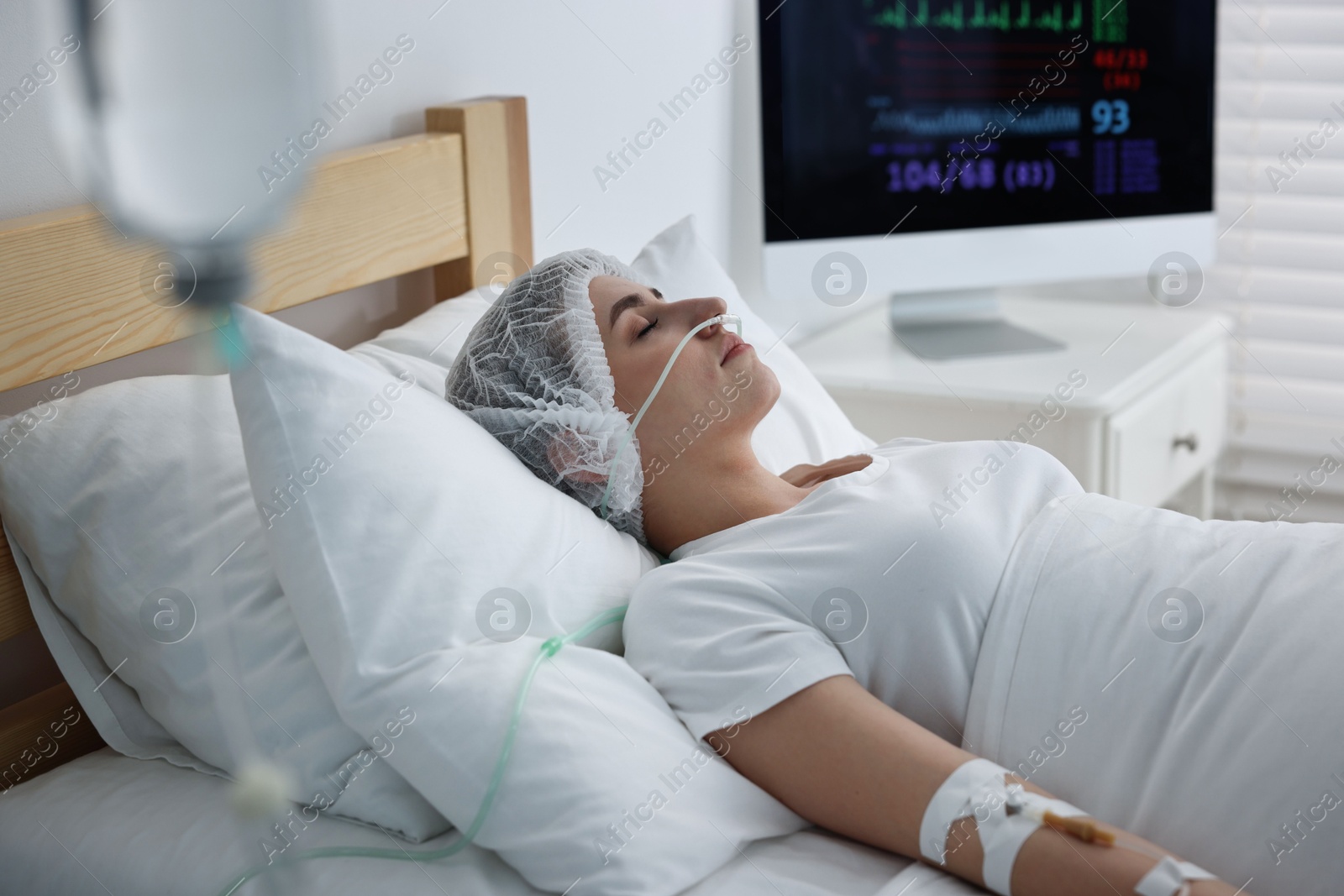 Photo of Coma patient. Young woman with intravenous drip in hospital bed