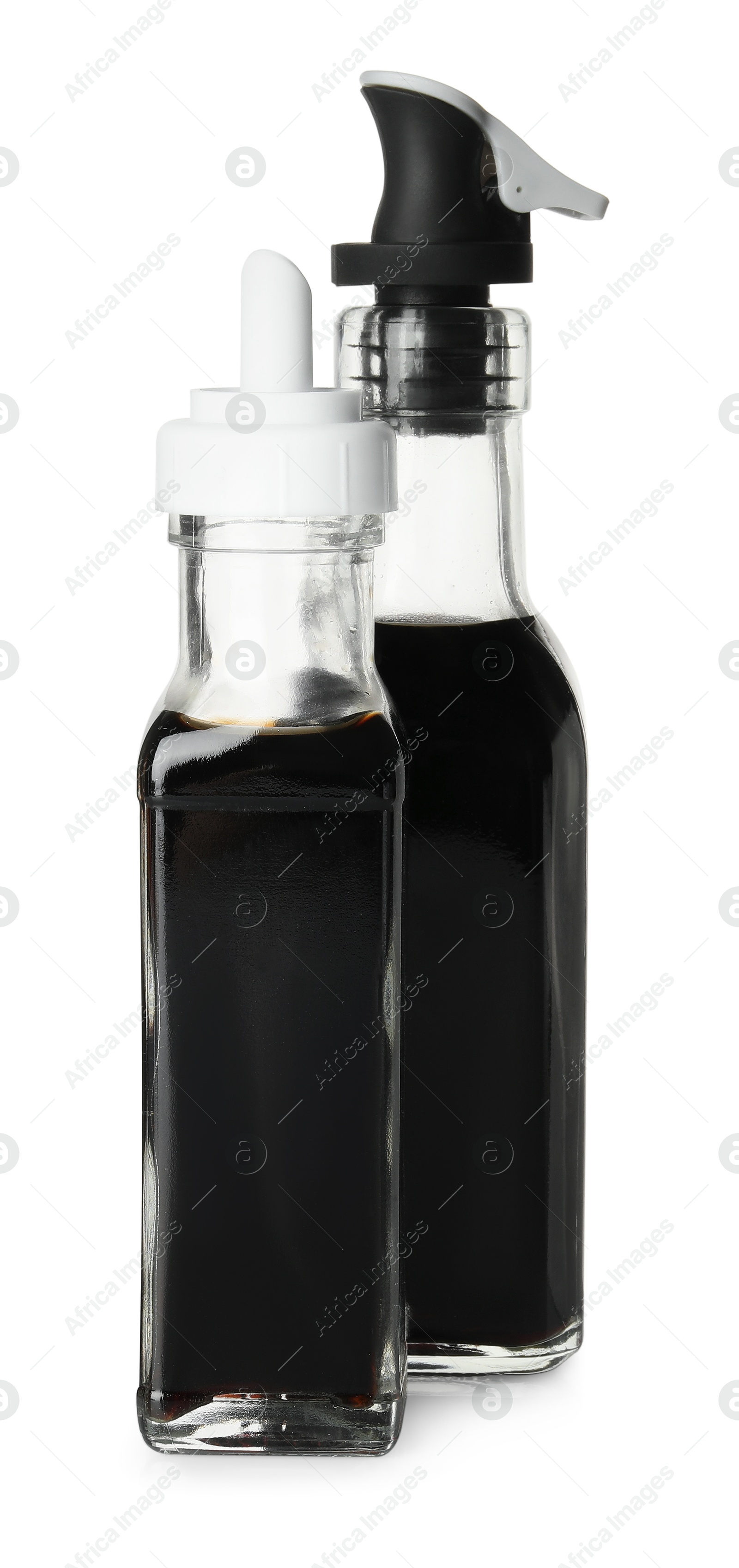 Photo of Balsamic vinegar in bottles isolated on white