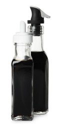 Photo of Balsamic vinegar in bottles isolated on white