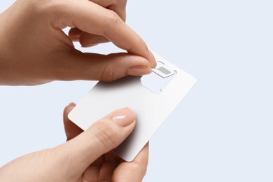 Photo of Woman removing SIM card from holder on white background, closeup