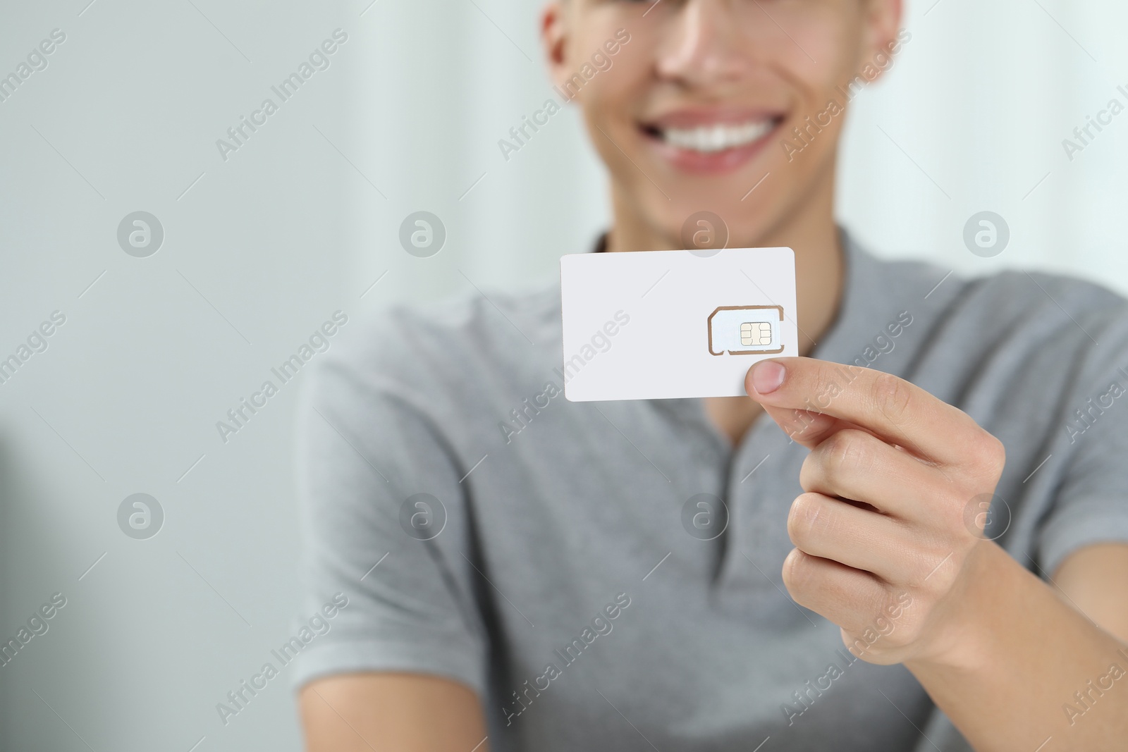 Photo of Man with SIM card at home, closeup. Space for text