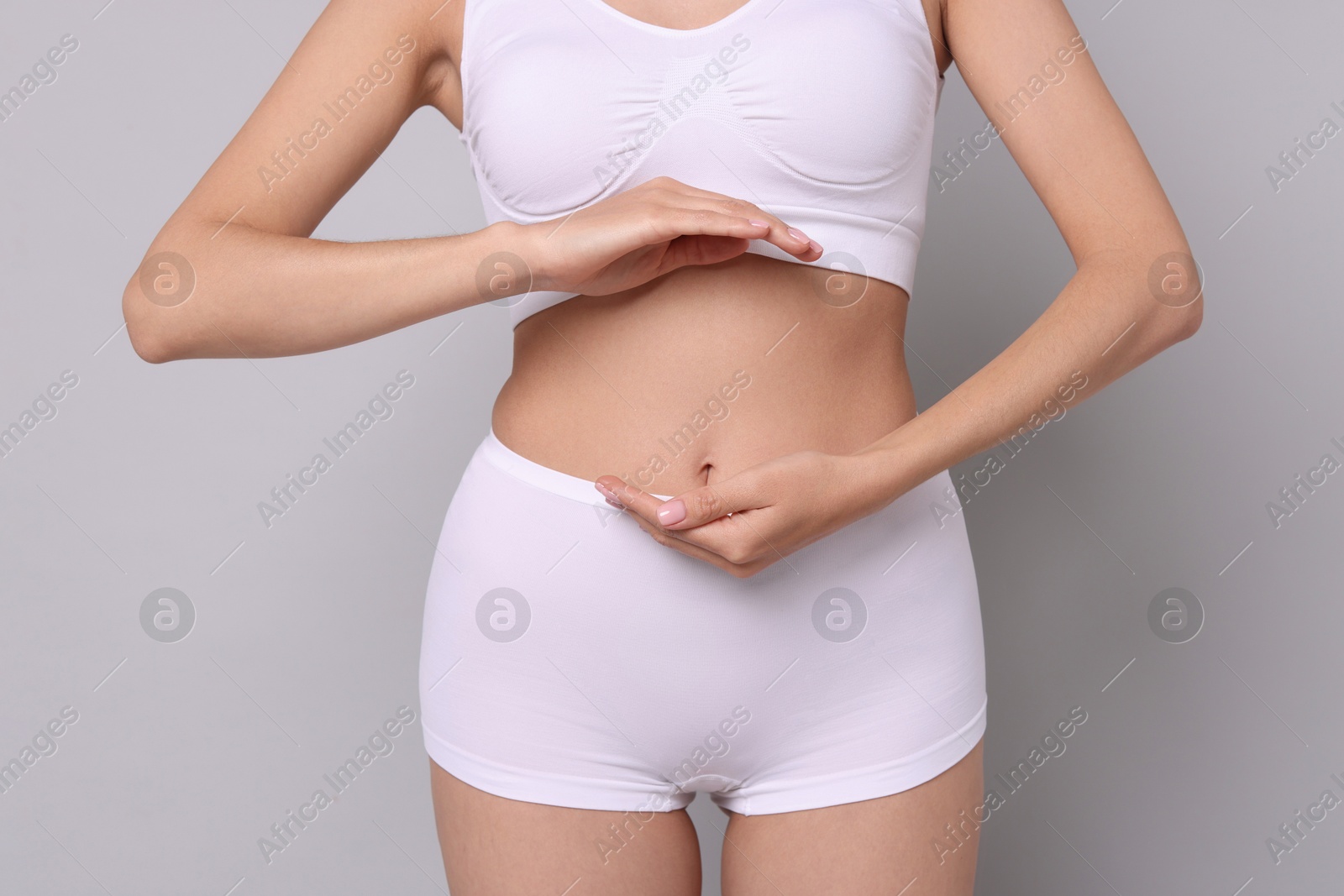 Photo of Diet and weight loss concept. Woman with slim body against light grey background, closeup