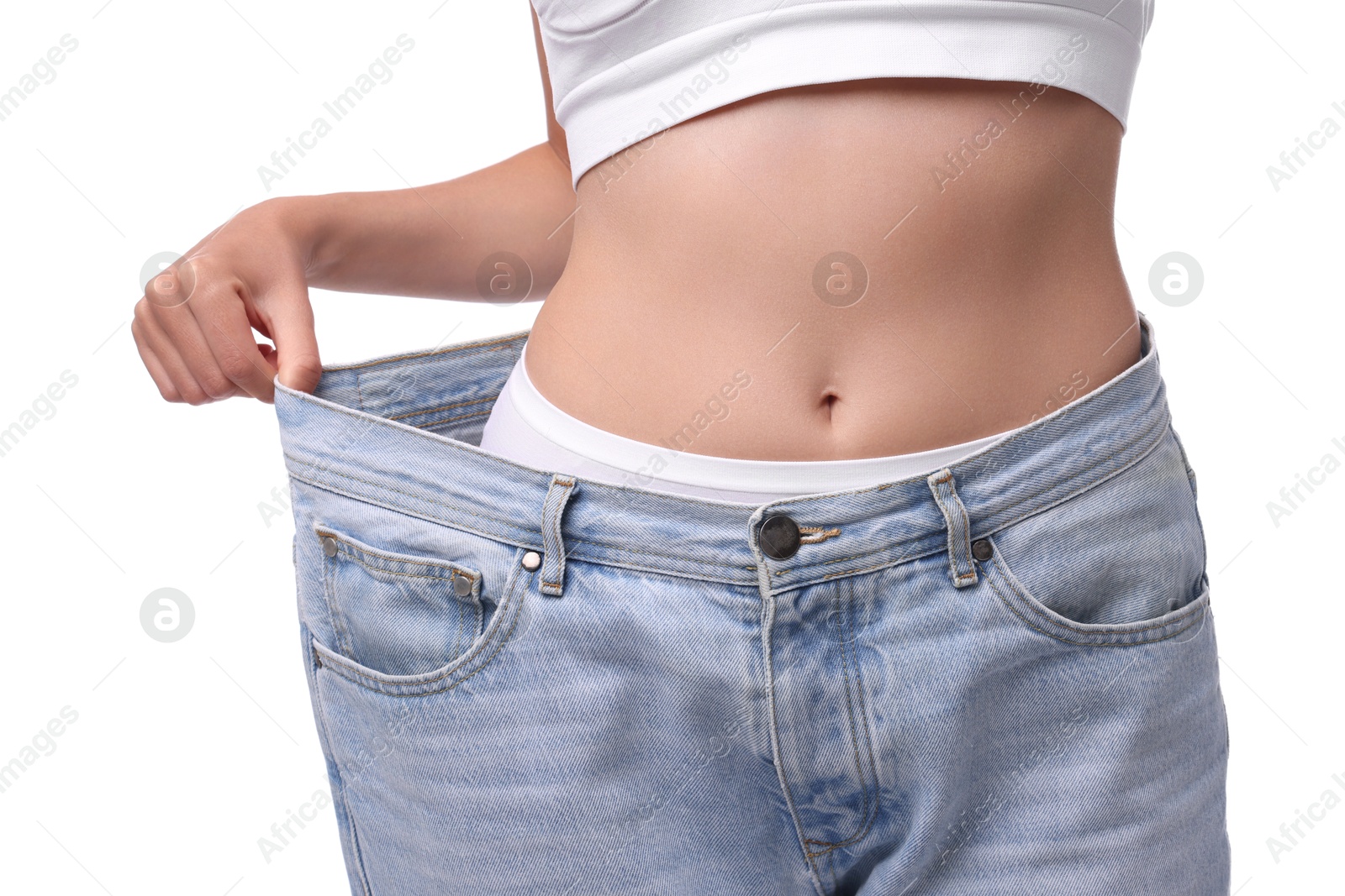 Photo of Diet and weight loss concept. Woman in big jeans showing her slim body on white background, closeup