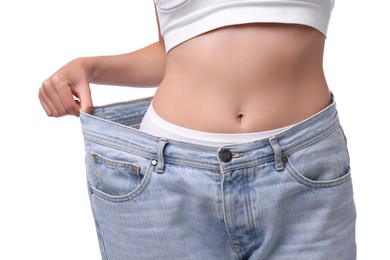 Photo of Diet and weight loss concept. Woman in big jeans showing her slim body on white background, closeup