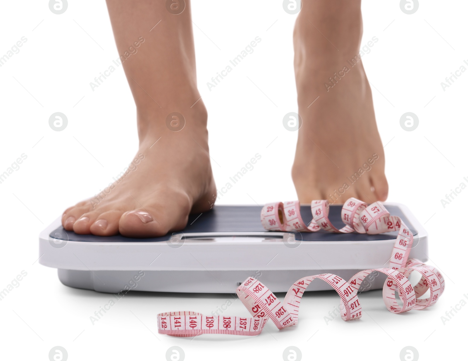 Photo of Diet and weight loss concept. Woman on floor scale and measuring tape against white background, closeup