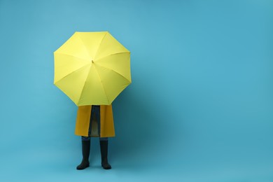 Photo of Man with yellow umbrella on light blue background, space for text