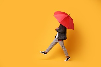 Photo of Man with red umbrella on yellow background, space for text