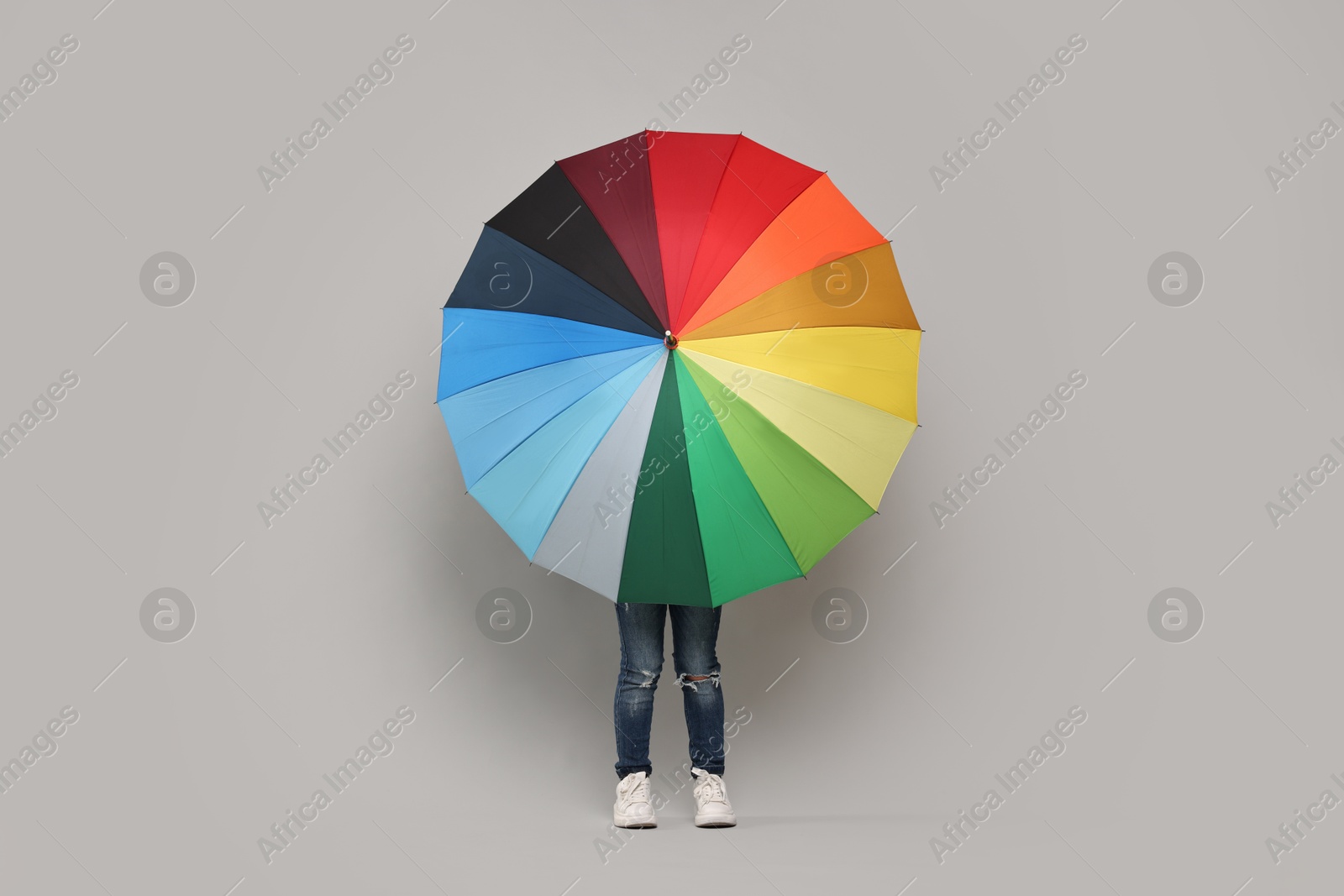 Photo of Little girl with colorful umbrella on light grey background