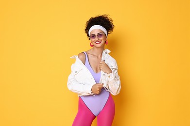 Photo of Aerobics. Happy woman in sportswear on orange background