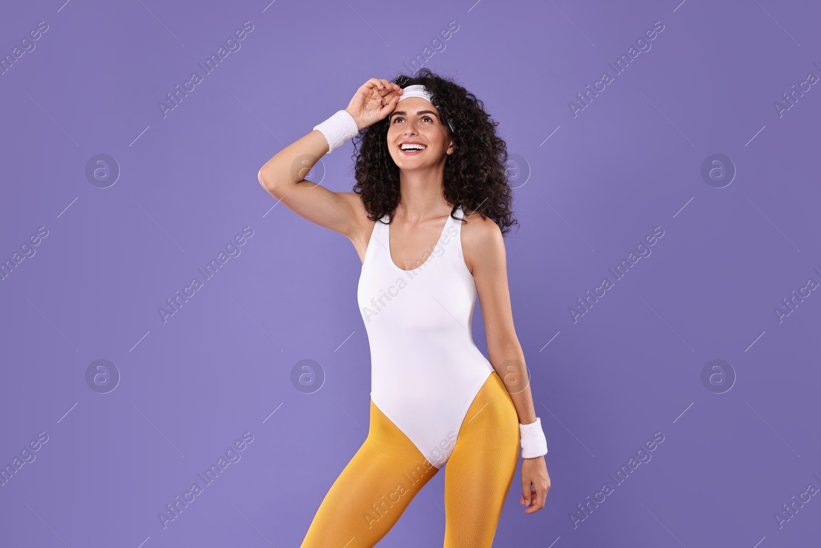 Photo of Happy woman in sportswear on purple background