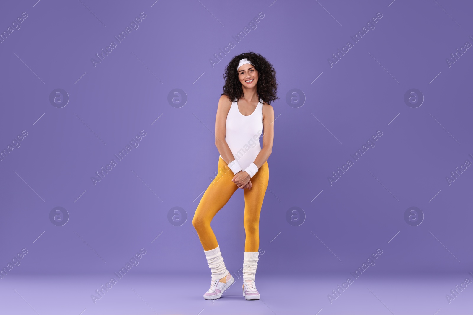 Photo of Happy woman in sportswear on purple background