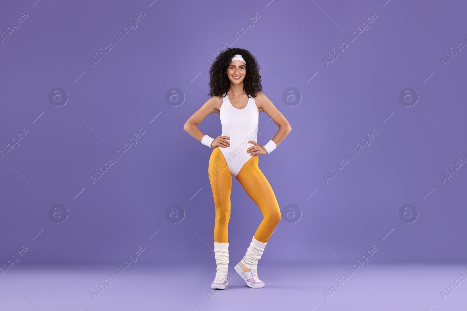 Photo of Happy woman in sportswear on purple background