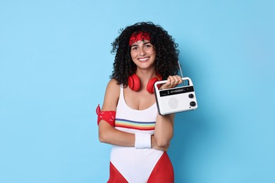 Photo of Aerobics. Happy woman with radio receiver on light blue background