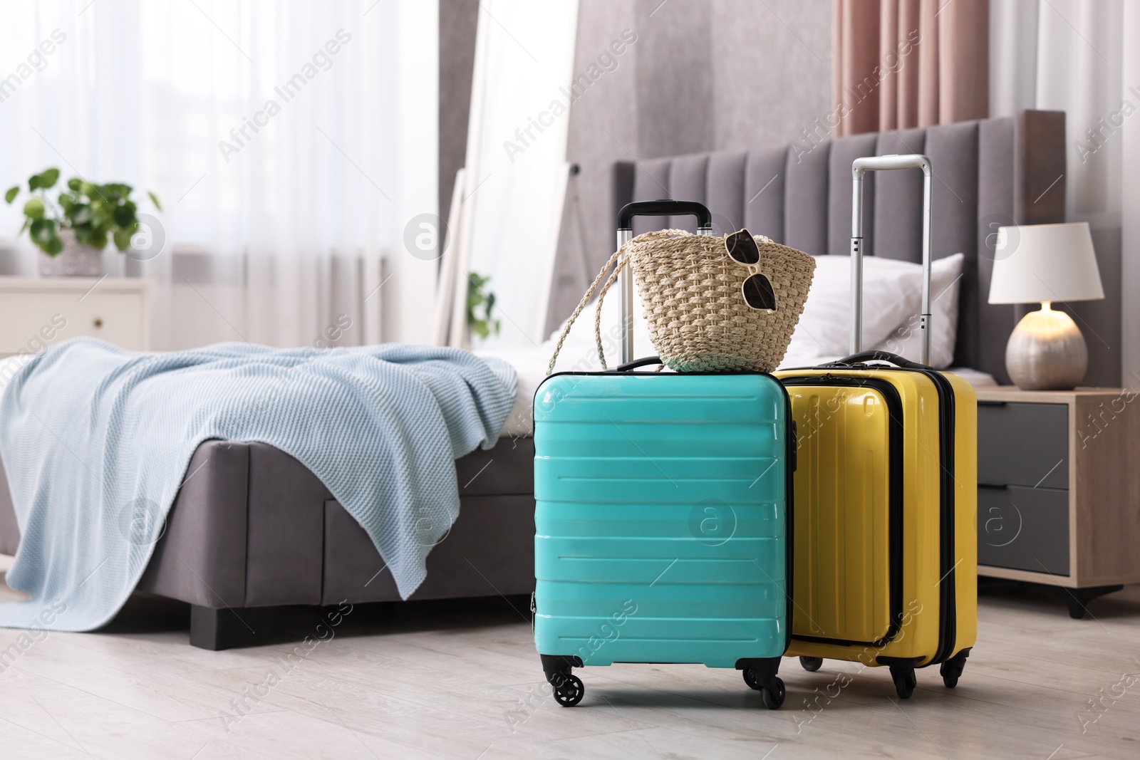 Photo of Color suitcases, bag and sunglasses in bedroom