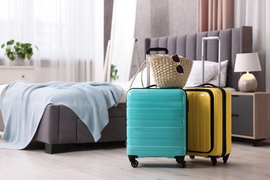 Color suitcases, bag and sunglasses in bedroom