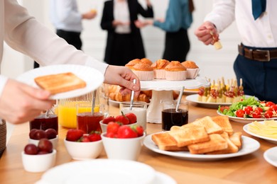 Coworkers having business lunch in restaurant, closeup