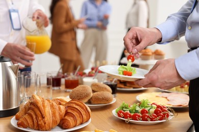 Coworkers having business lunch in restaurant, closeup