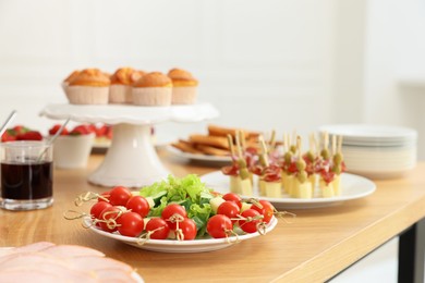 Different meals served on wooden table indoors. Buffet menu