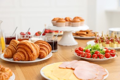 Different meals served on wooden table indoors. Buffet menu