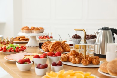 Photo of Different meals served on wooden table indoors, selective focus. Buffet menu