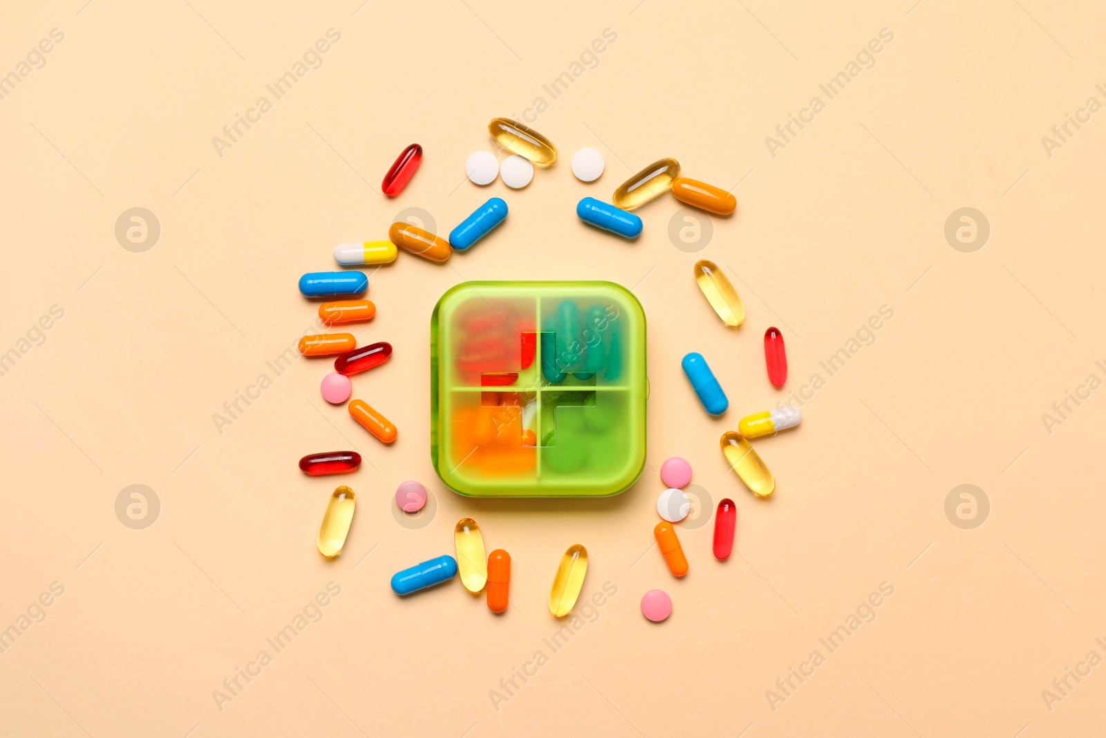 Photo of Different pills and organizer on beige background, flat lay