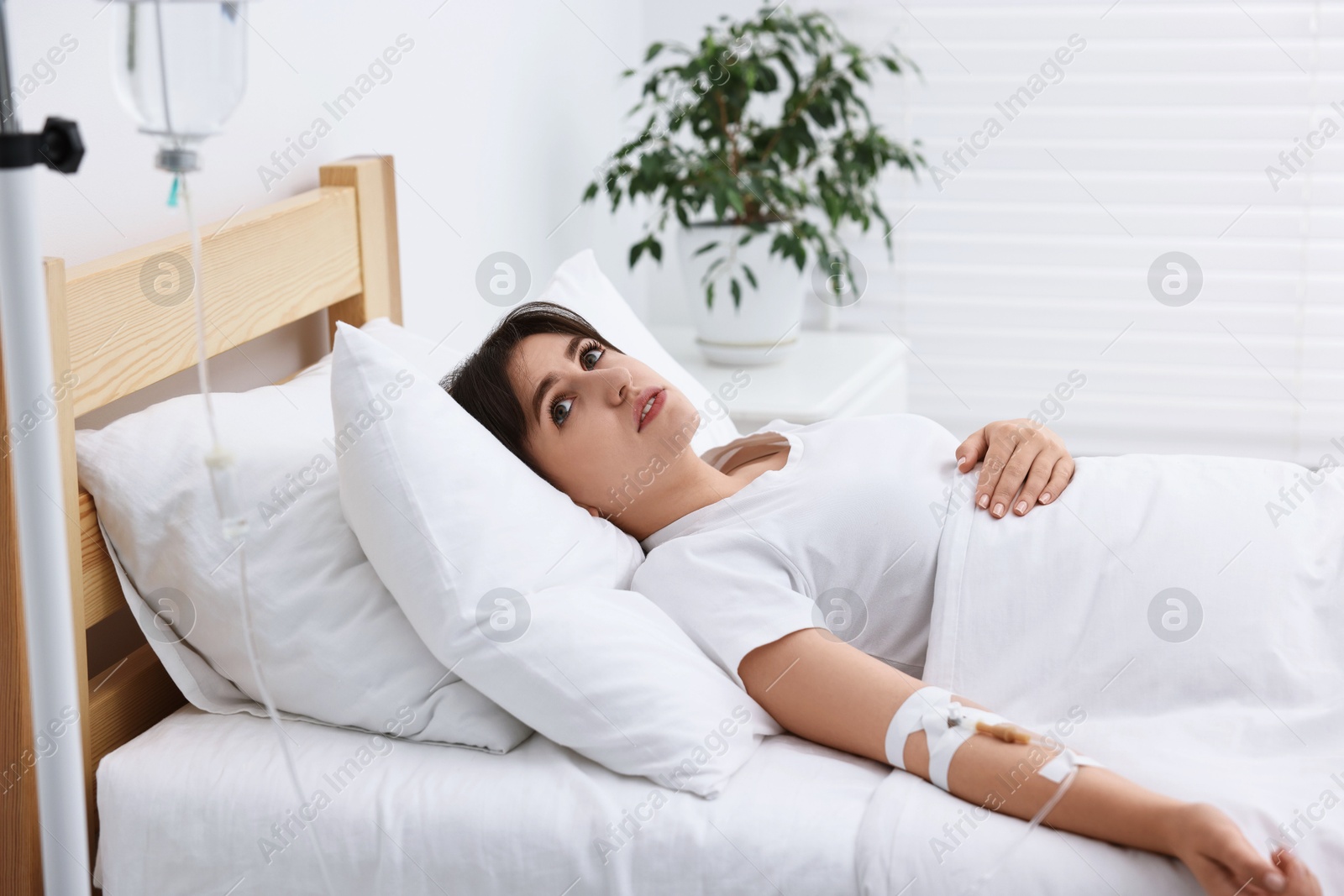 Photo of Young woman with intravenous drip in hospital bed