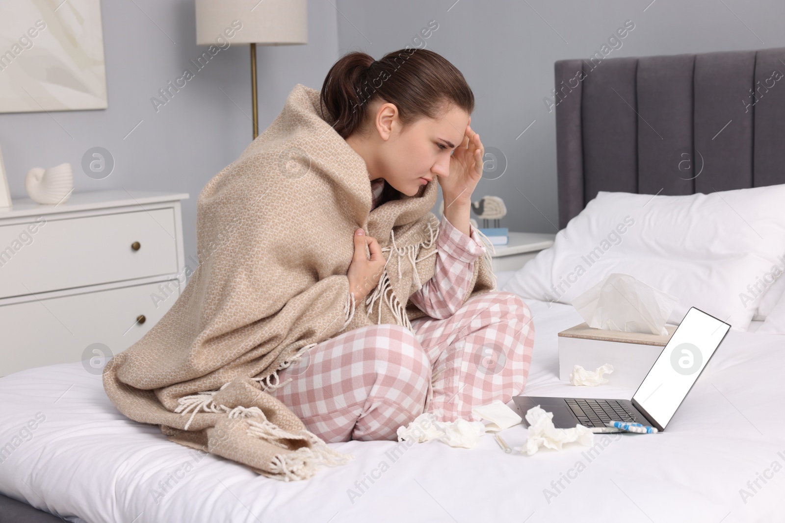 Photo of Sick woman having online consultation with doctor via laptop at home