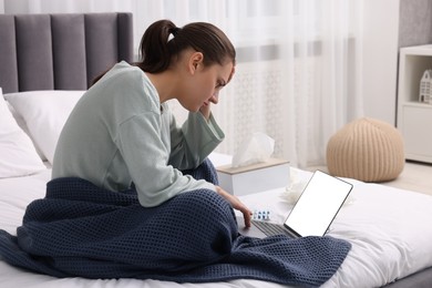 Sick woman having online consultation with doctor via laptop at home