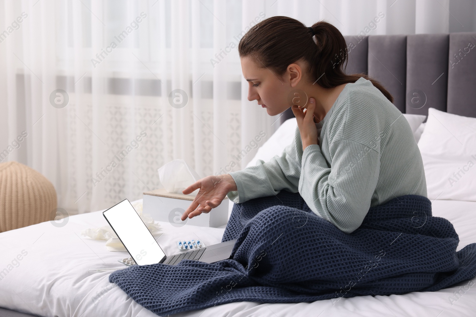 Photo of Sick woman having online consultation with doctor via laptop at home